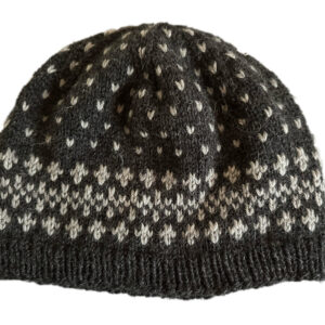 Starfall stranded color work hat in light grey on charcoal grey background. Pattern evokes celestial sky and the trails of comets.